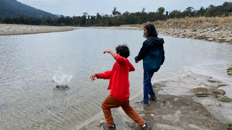Children throwing stones into a river inside Namdapha National Park