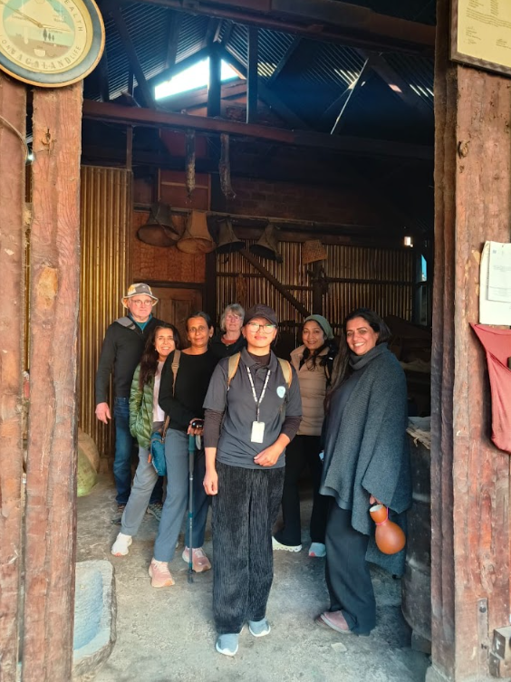 Heritage walk group standing in the entrance of a wooden Angami house