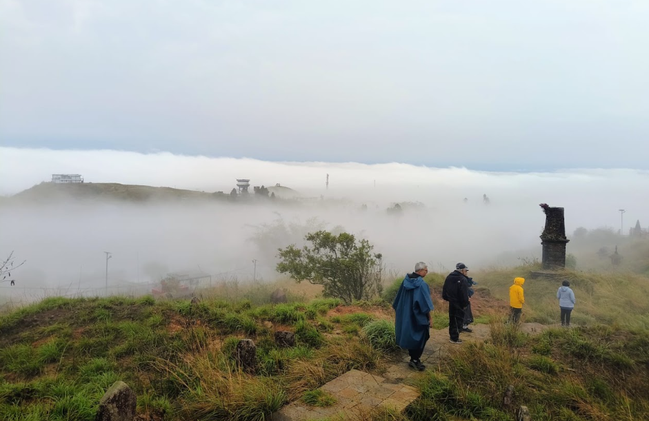 Travellers on a misty hilltop at dawn in Northeast India