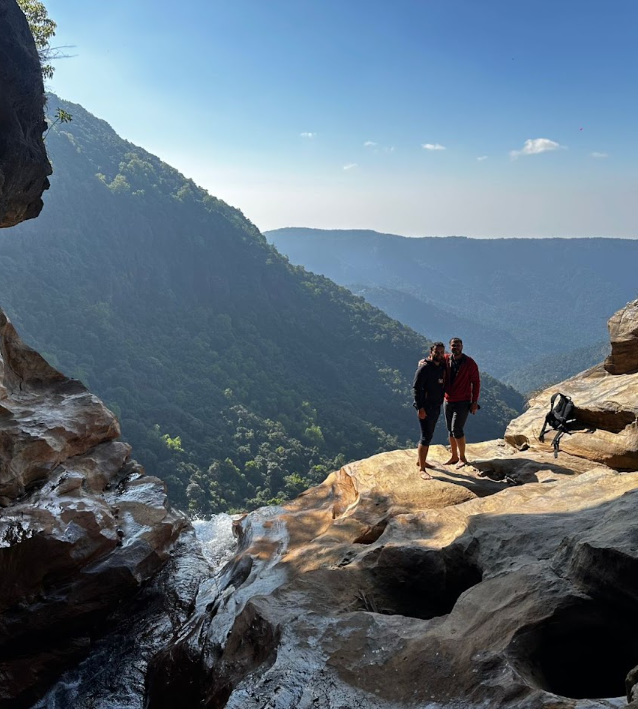 Two travellers on rocks above a deep valley near Sohra